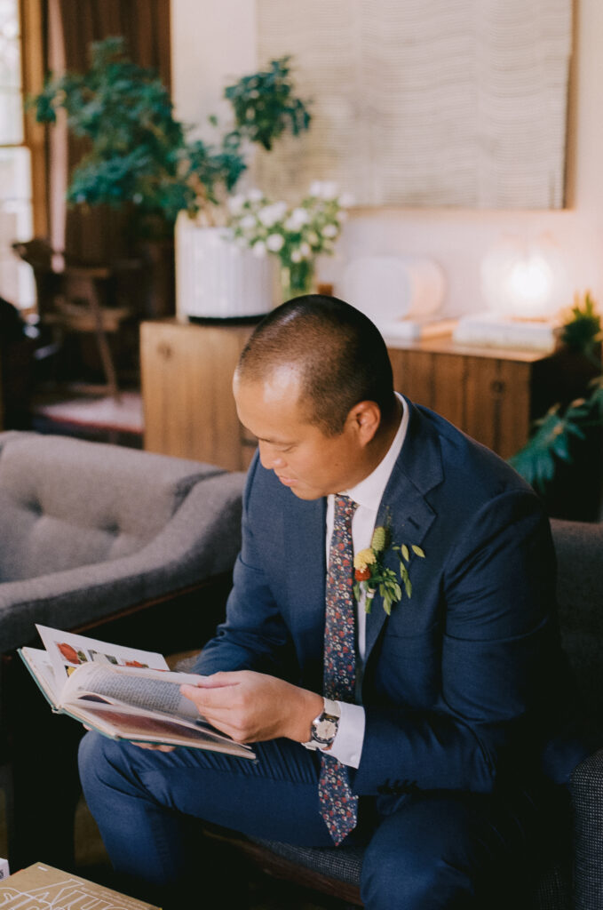 Groom looking at a book in the morning of the wedding