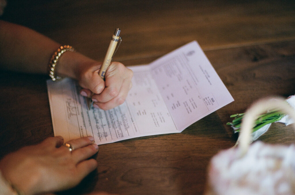 Close up of witness signing the marriage license 