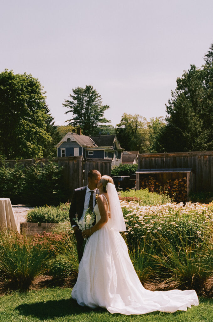 Bride and groom kissing in a flower garden