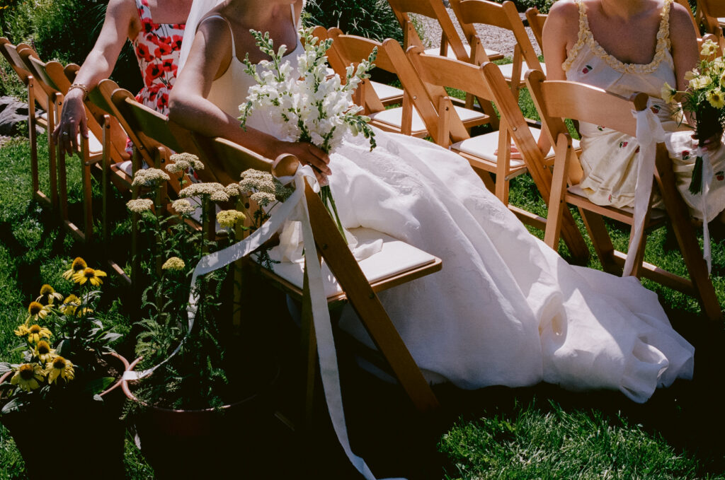 Close up of the bride sitting with friends in the ceremony space 
