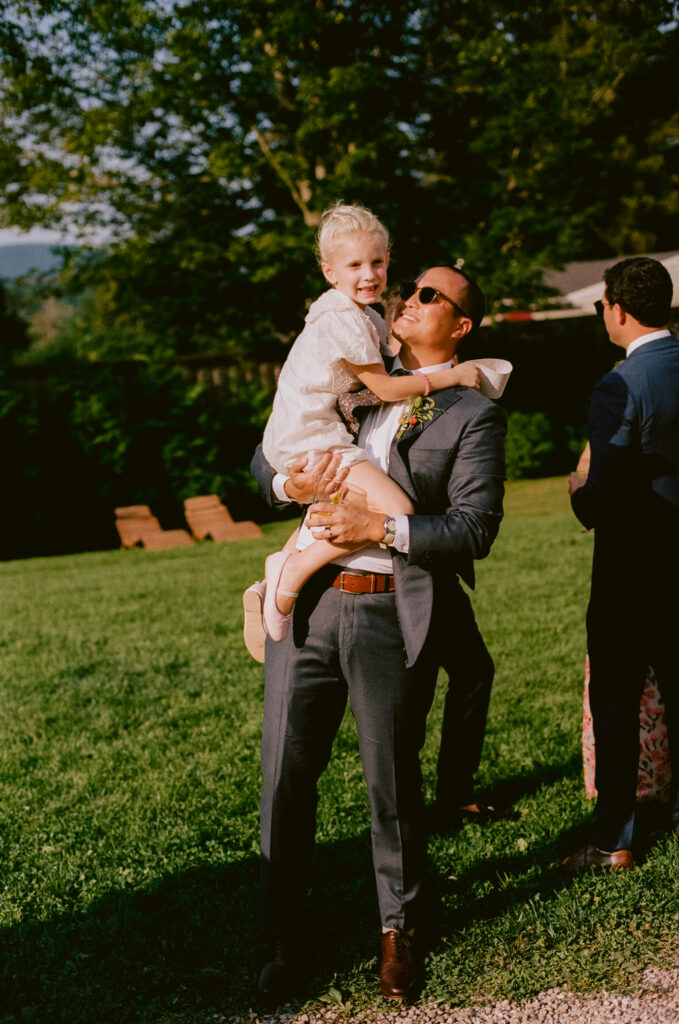 Groom playing with a child during the wedding reception
