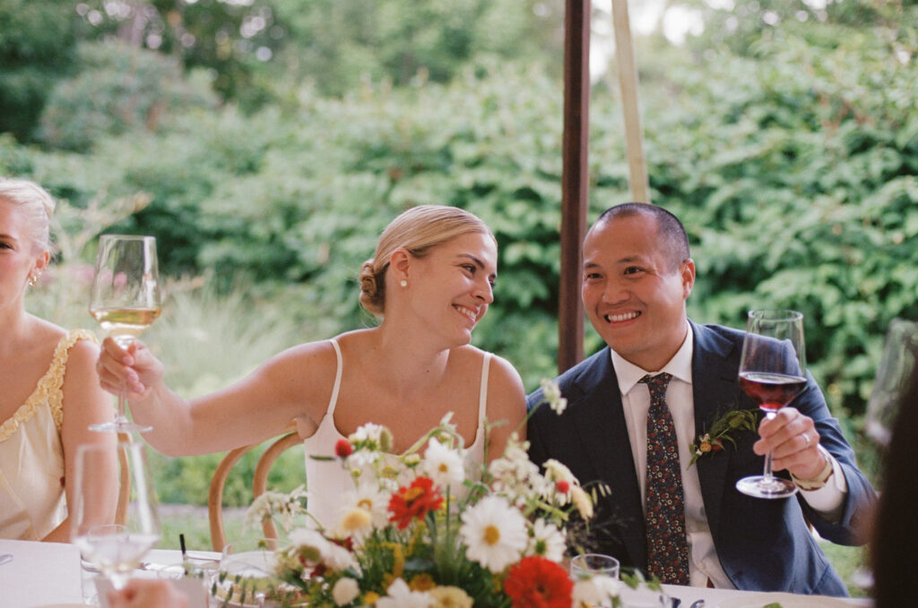Bride and groom smiling during toasts
