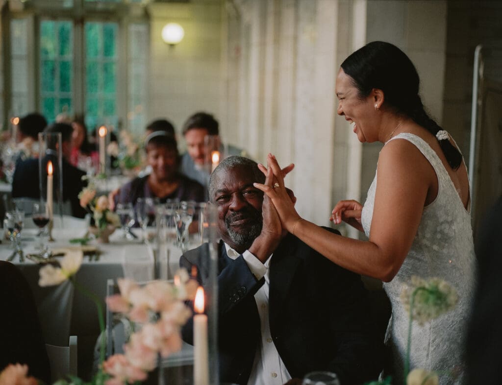 Bride laughing with a wedding guest at a prospect park boathouse wedding reception dinner