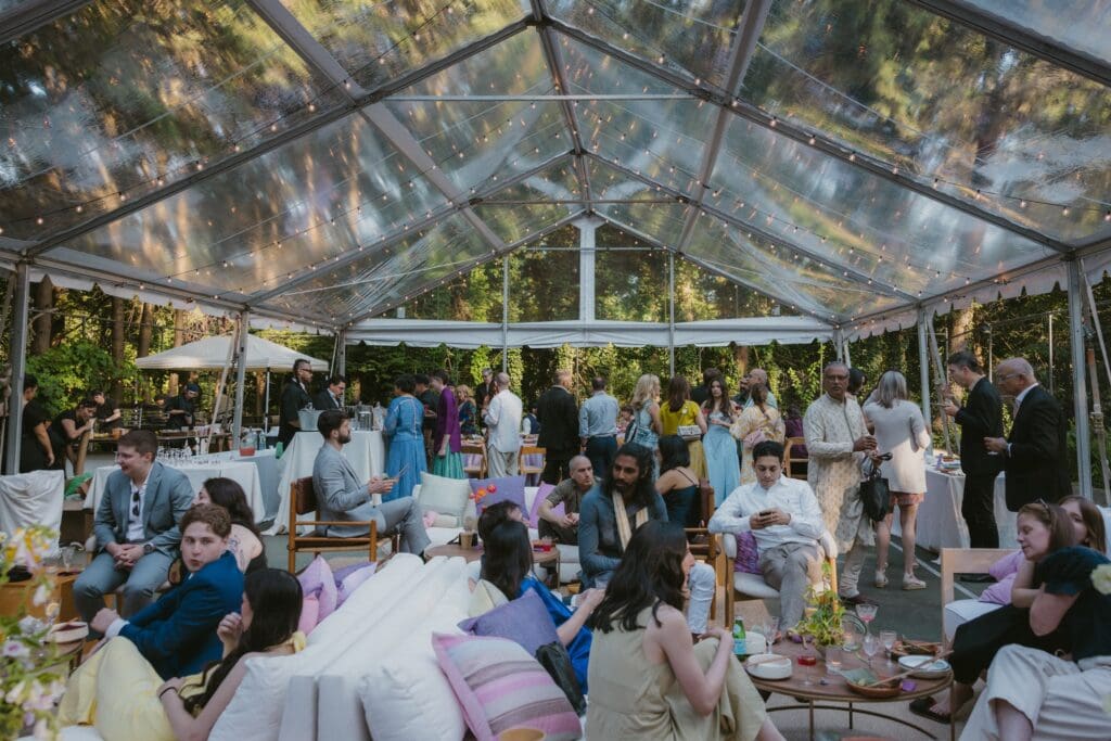 Tented reception space with wedding guests at a whimsical backyard wedding