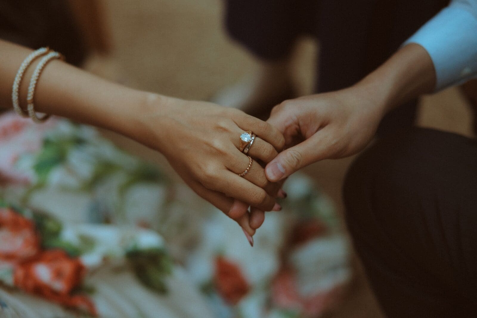 Close up of the bride and groom holding hands 