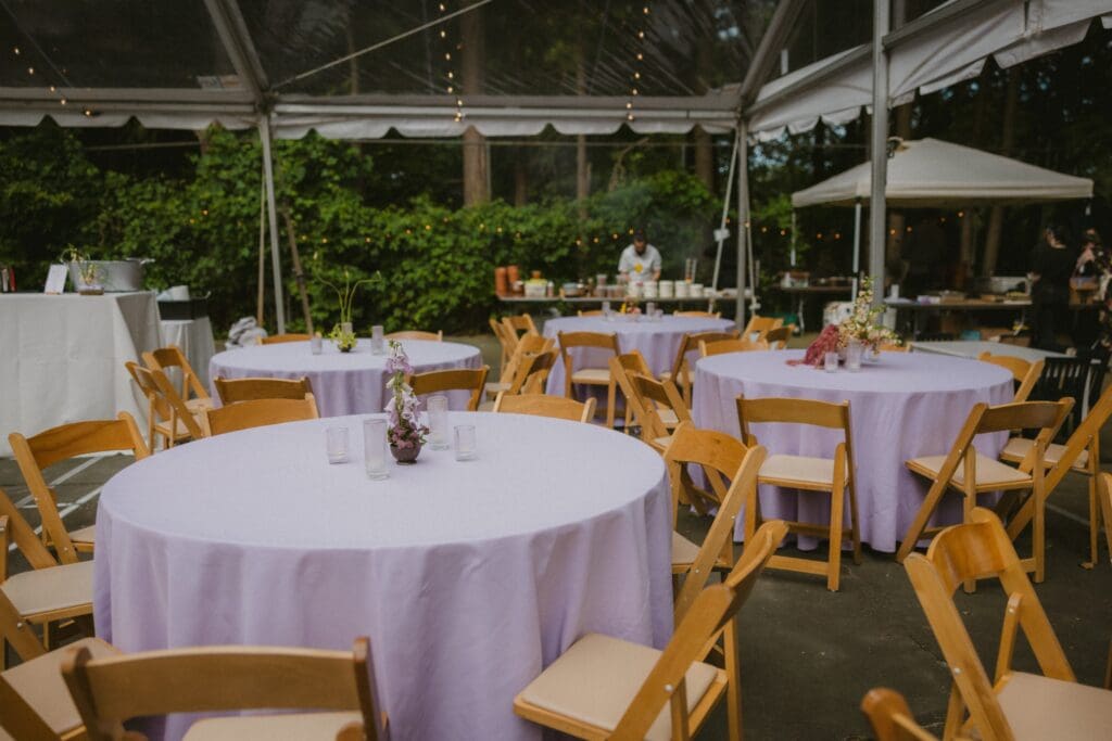 Whimsical backyard wedding tented reception space with purple color palette