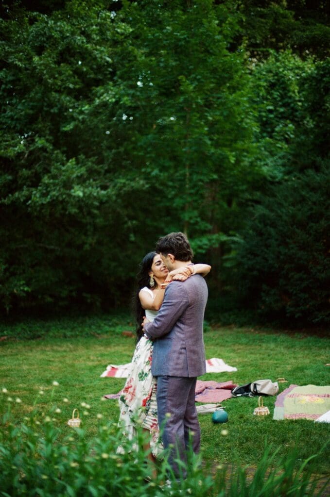 Bride smiling with her arms wrapped around the groom's neck at a whimsical backyard wedding