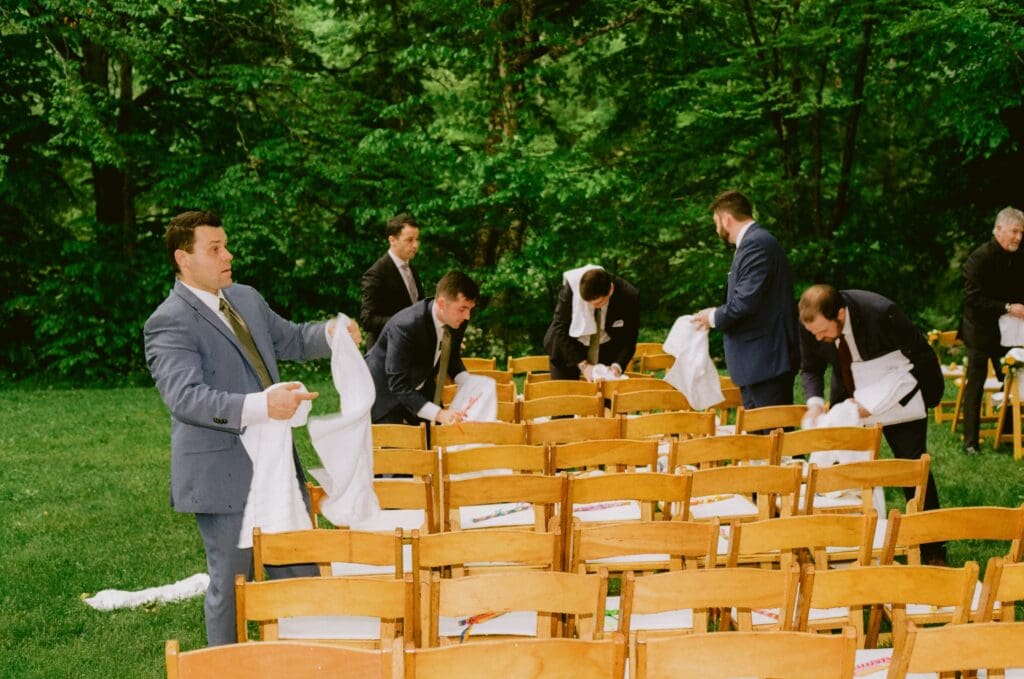 Guest drying off the ceremony chairs after a rain shower