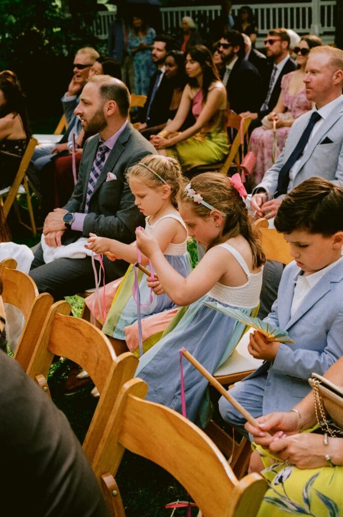 Children playing with the ribbon wands during the ceremony