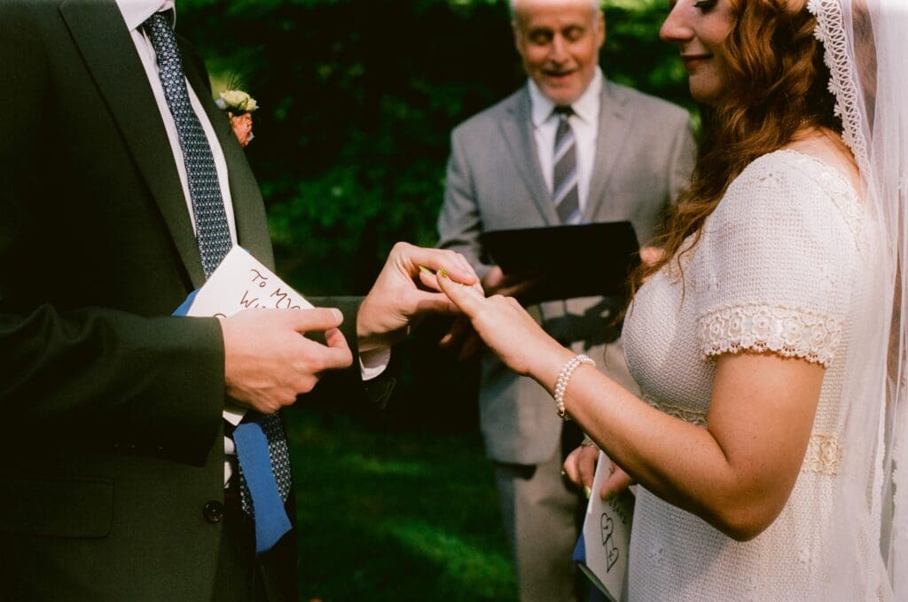 Groom placing the wedding ring on the bride's finger