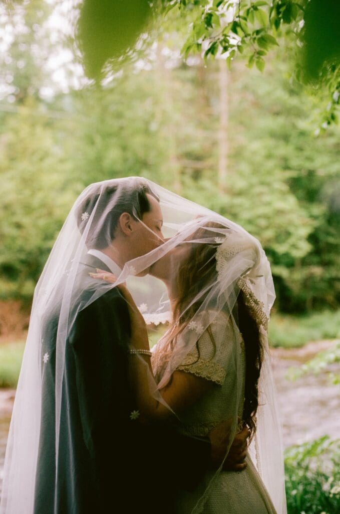Bride and groom kissing under the veil 
