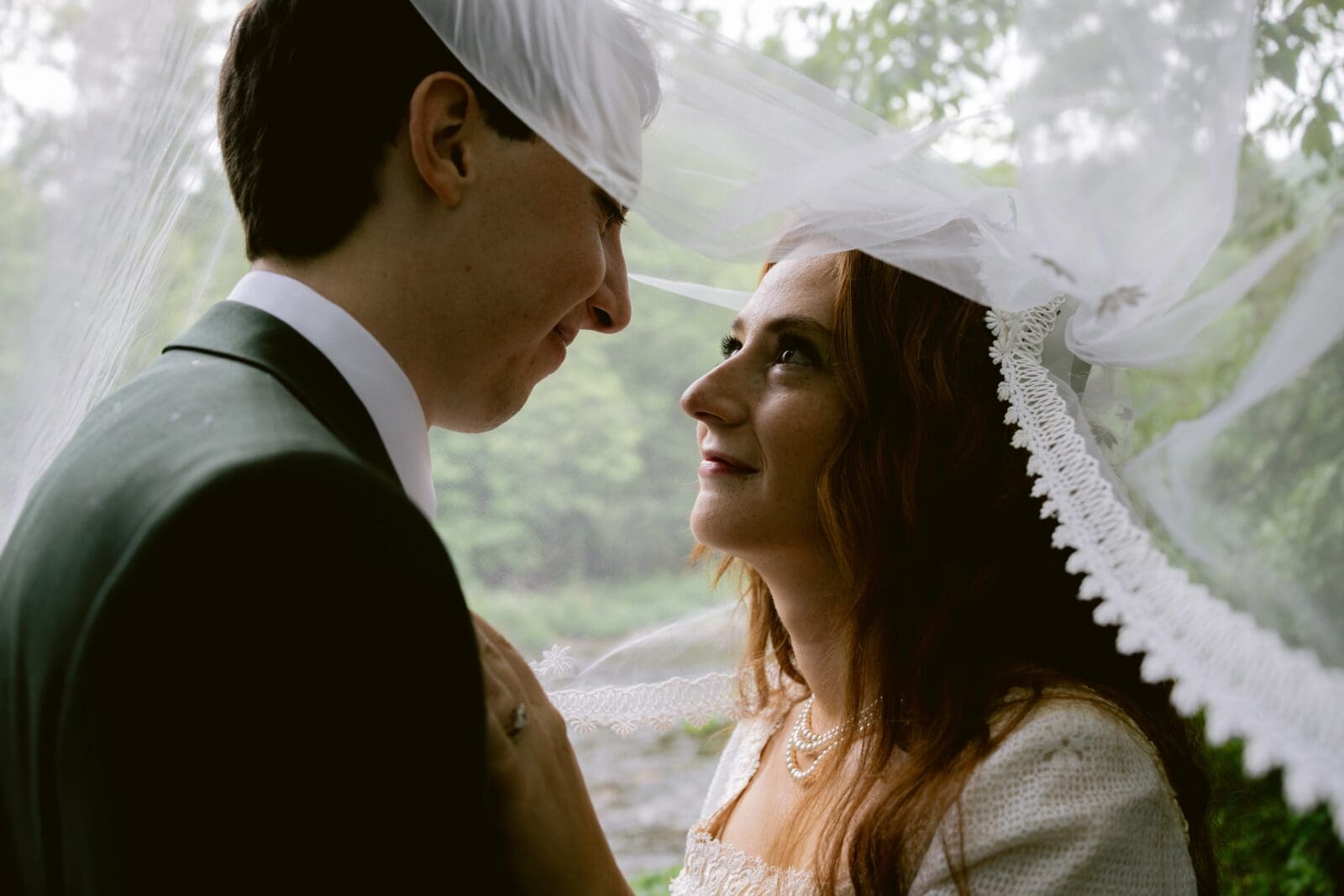Bride and groom looking at each other under the veil 