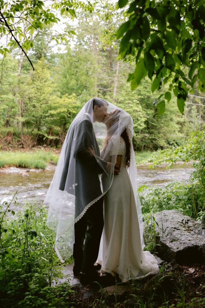 Bride and groom kissing under the veil 