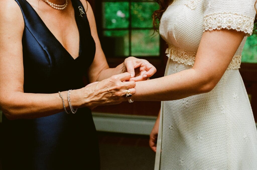 Mother of the bride putting a bracelet on the bride's wrist