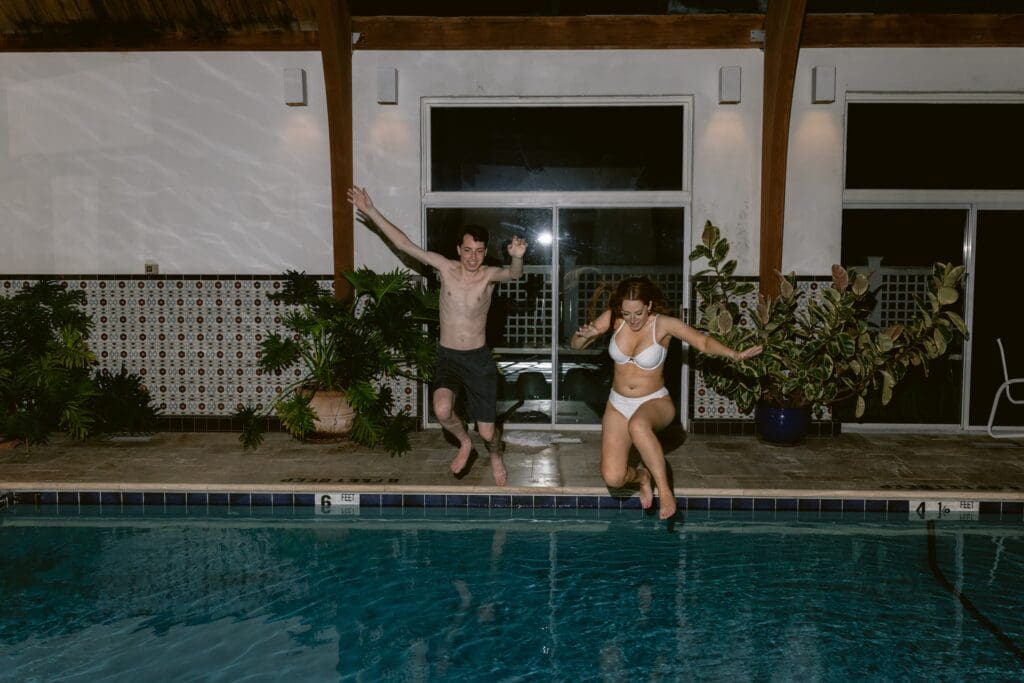 Bride and groom jumping into a pool