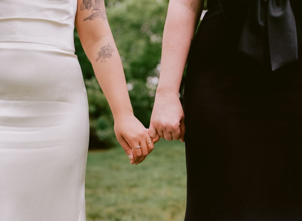 Close up of brides holding pinkies 