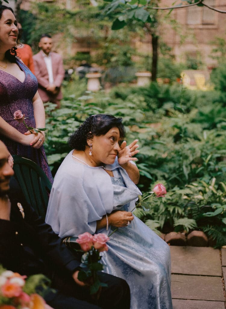 Bride's mother crying during the ceremony at a New York City garden wedding
