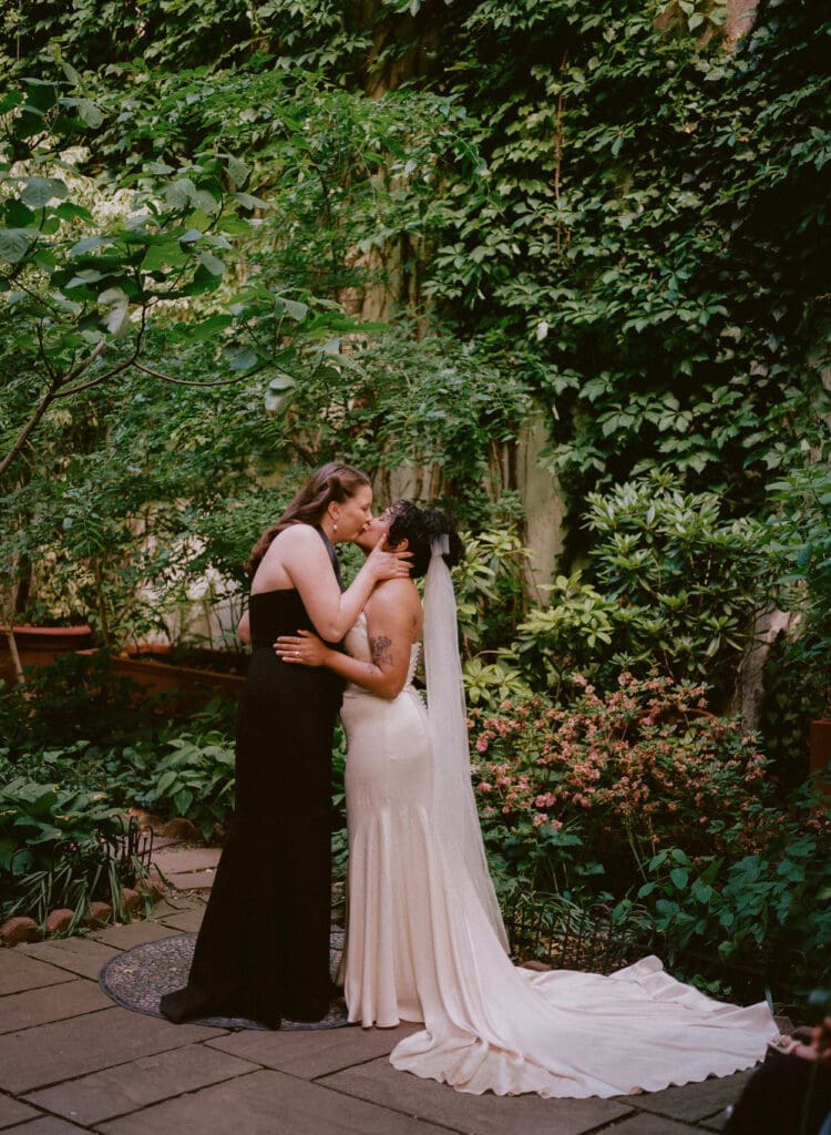 Brides sharing their first kiss as a married couple at a New York City garden wedding