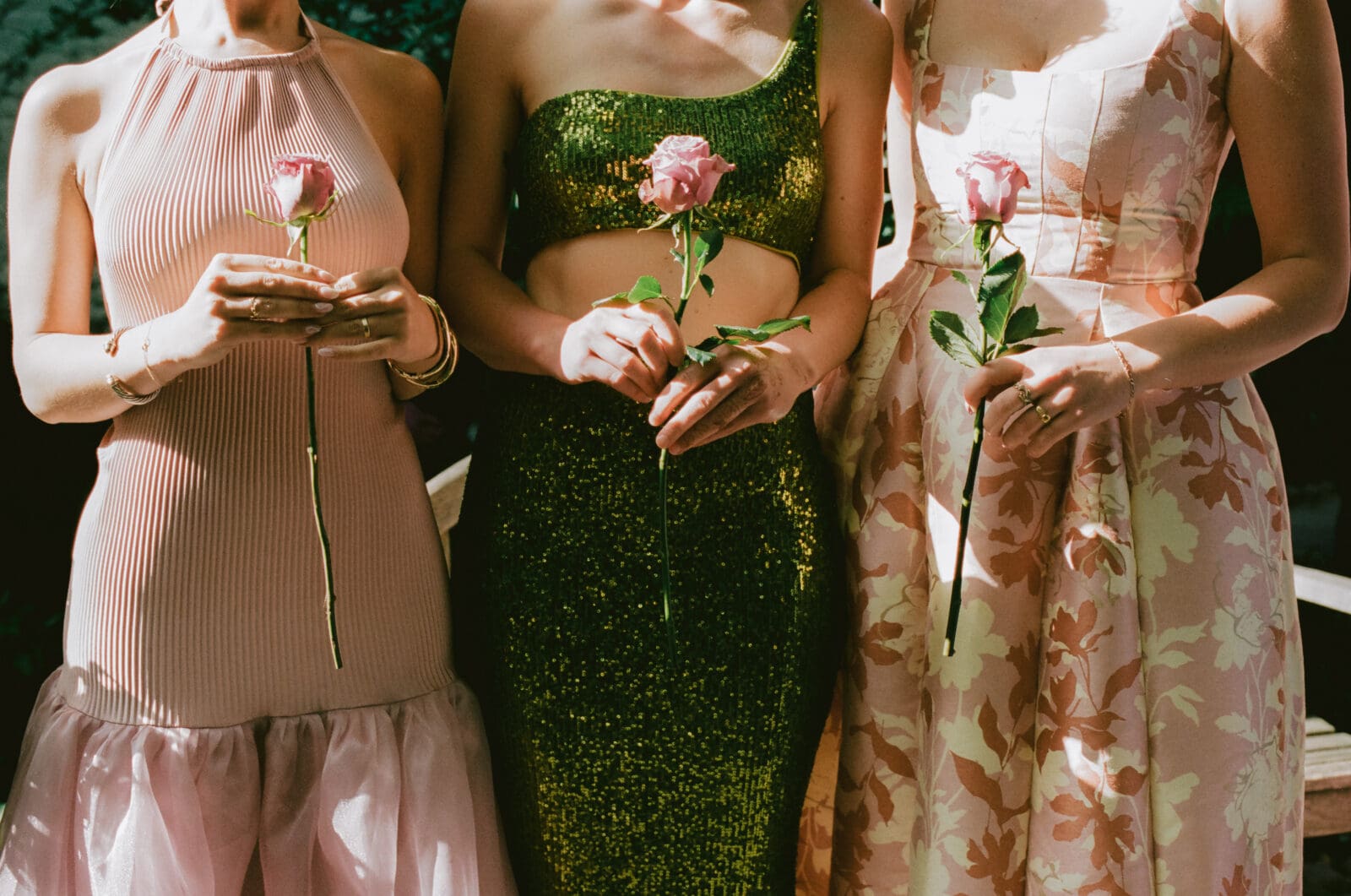 Close up of three wedding guests' outfits 