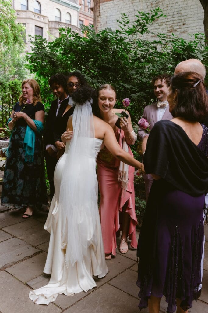 Bride hugging a wedding guest during cocktail hour at a New York City garden wedding