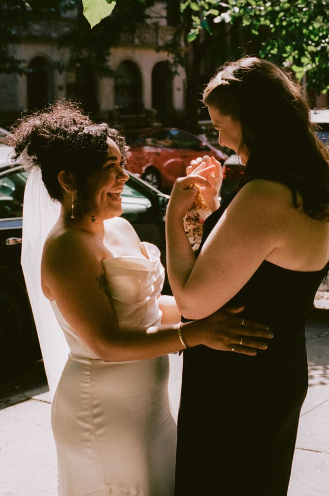 Brides smiling at each other during cocktail hour