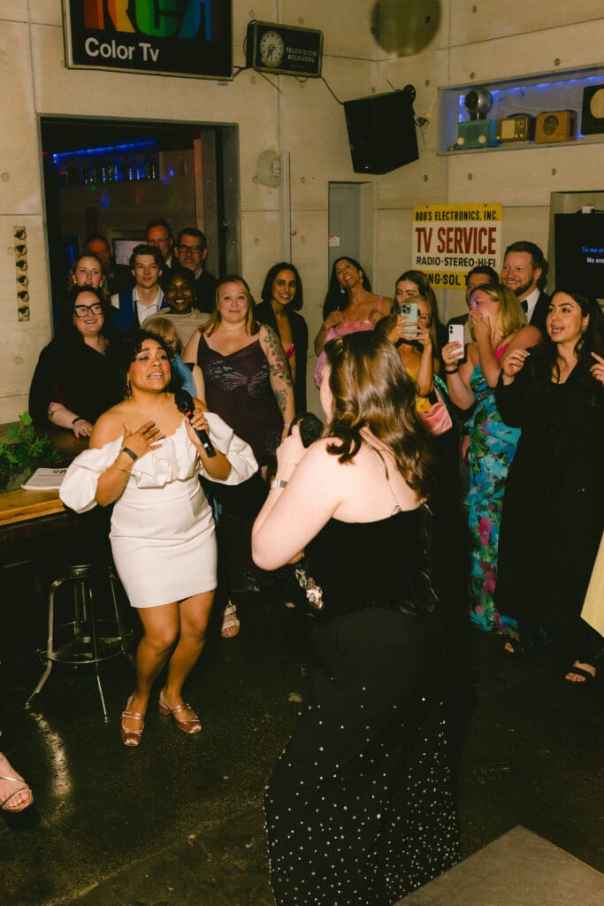 Brides singing to each other during karaoke at their afterparty 