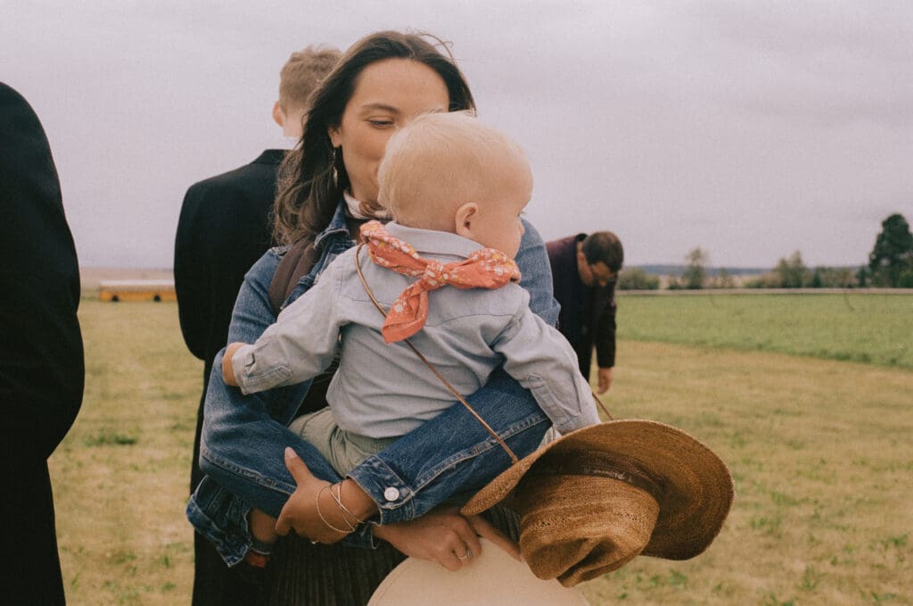 Wedding guest holding a baby in a cowboy outfit