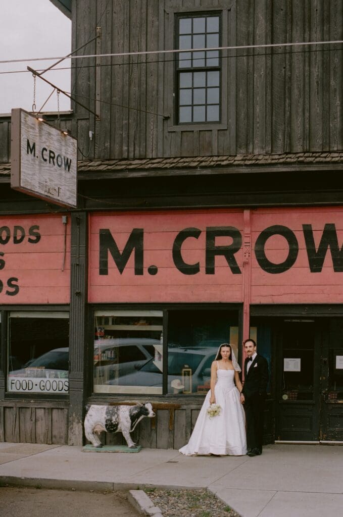 Bride and groom standing in front of their reception restaurant at a western mountain wedding