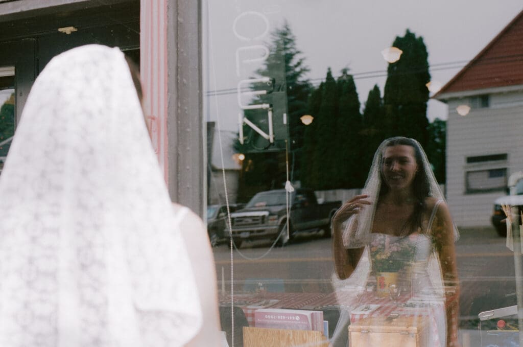 Bride looking at herself in a window