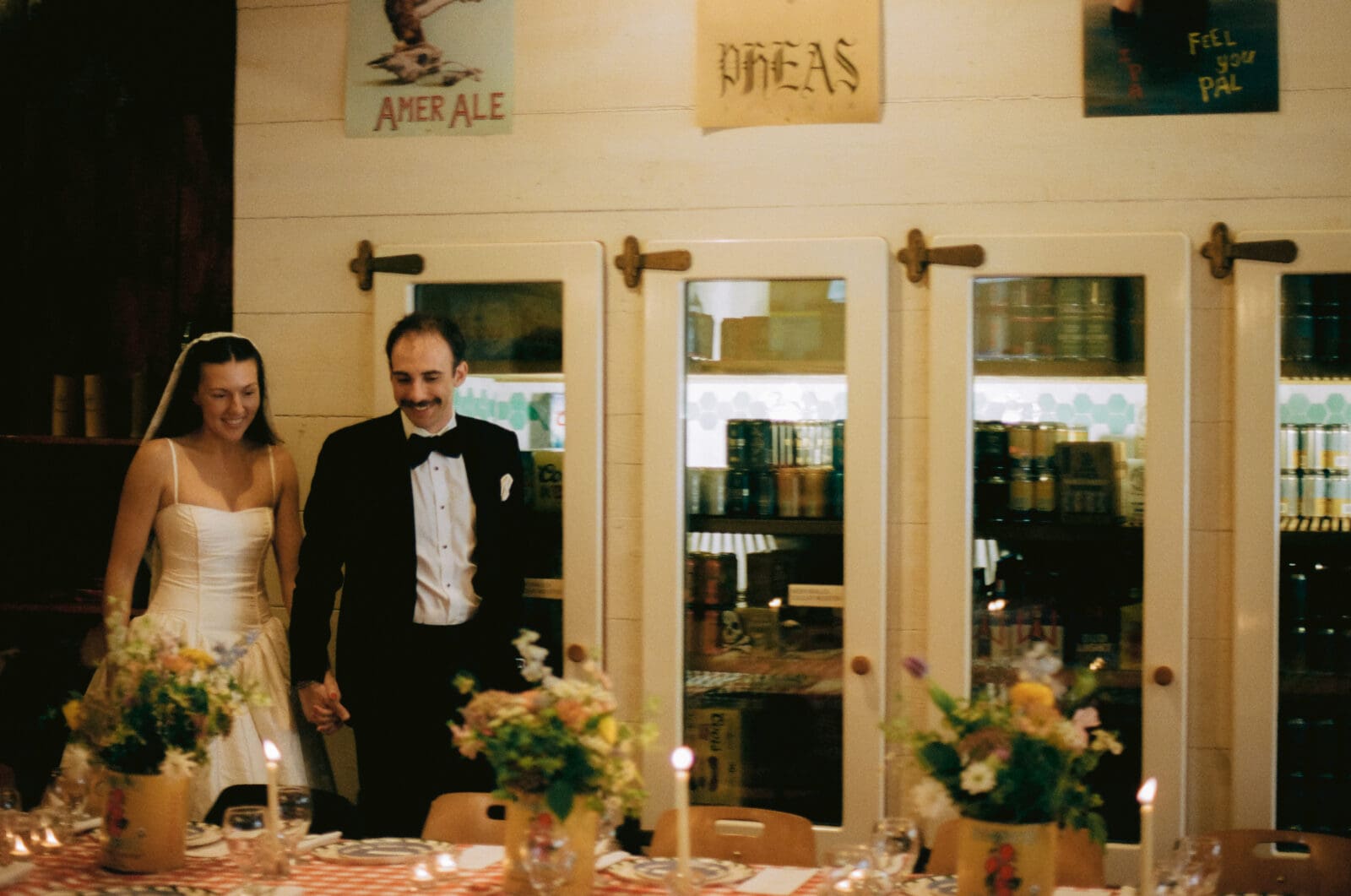 Bride and groom looking at their wedding reception dinner tables in a general store