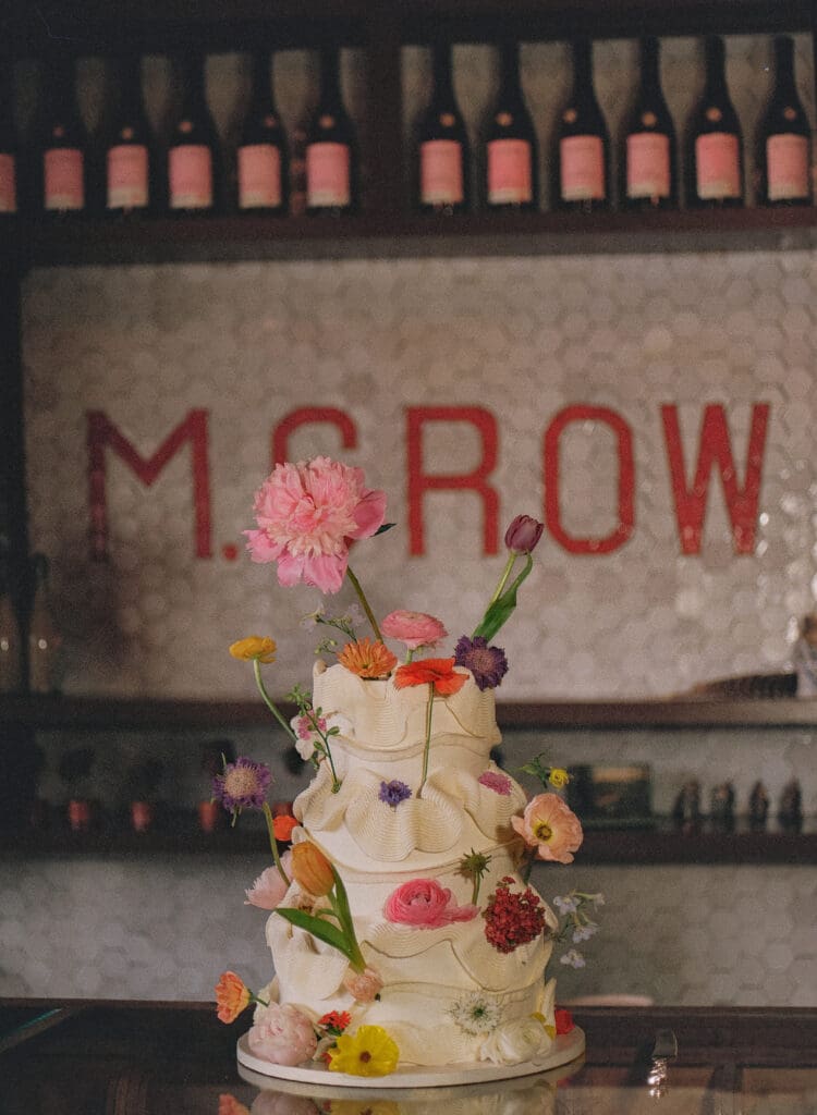 Three tiered wedding cake covered in flowers