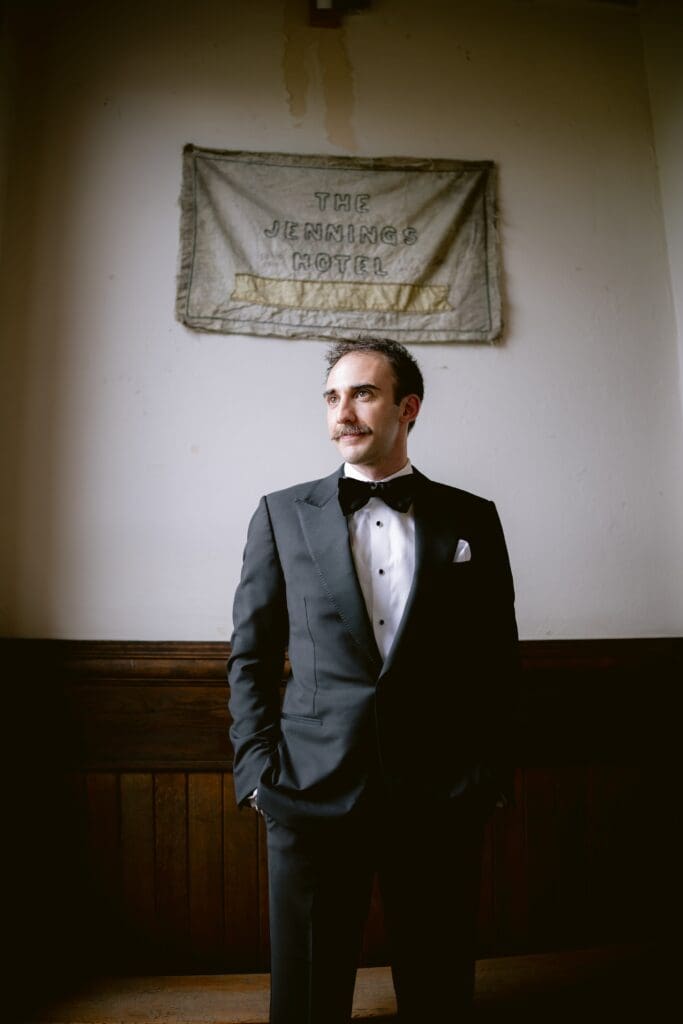 Portrait of the groom in front of the hotel sign