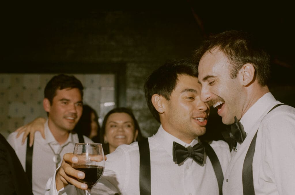 Bride laughing with a groomsman on the dance floor