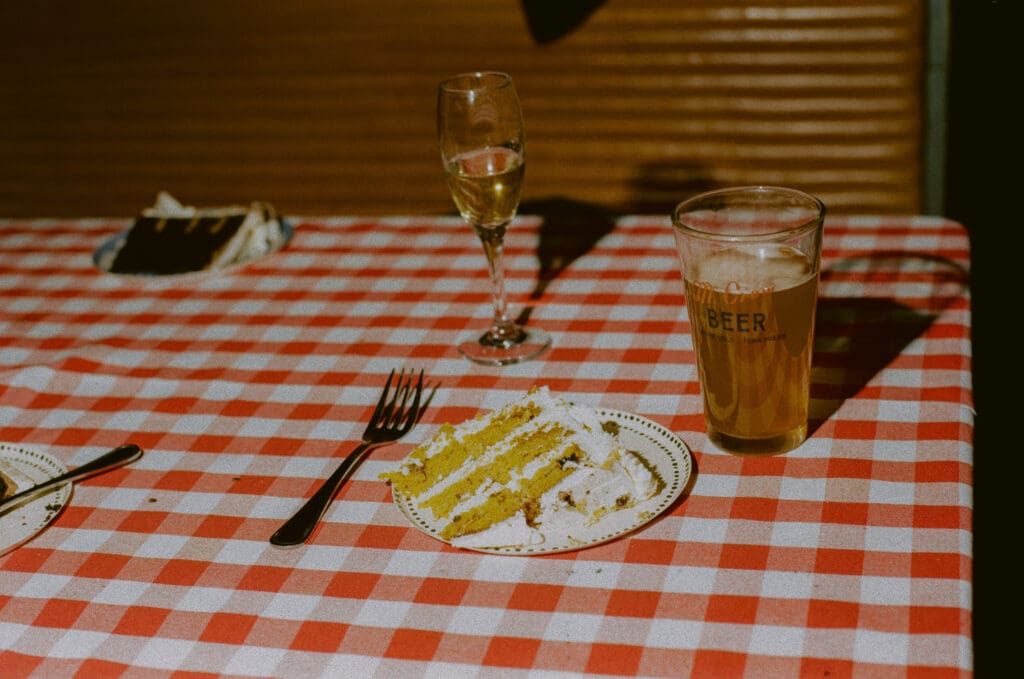 Slice of cake and glass of beer on a red and white check table
