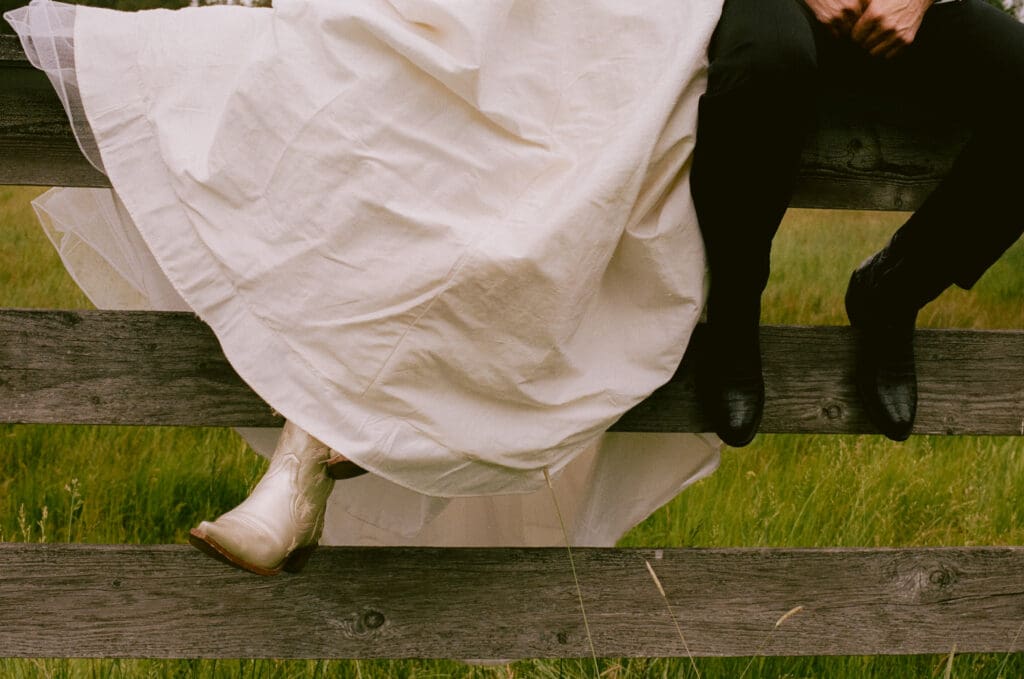 Close up of the bride and groom's feet resting on a fence